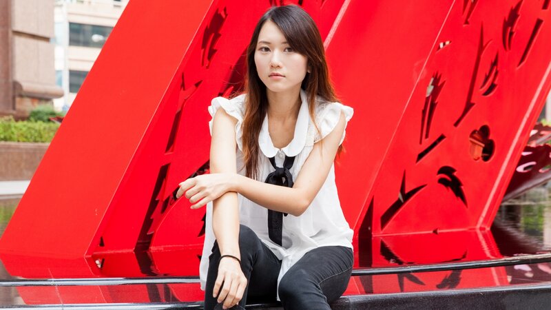 woman sitting by red sculpture