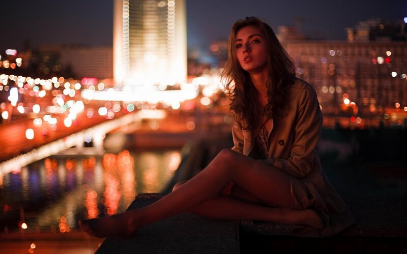 woman sitting by river at night