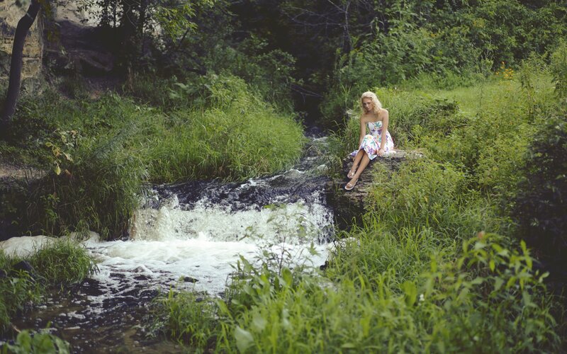 Woman Sitting by Stream — Green, Serene, Summer
