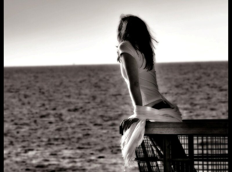 woman sitting by the sea
