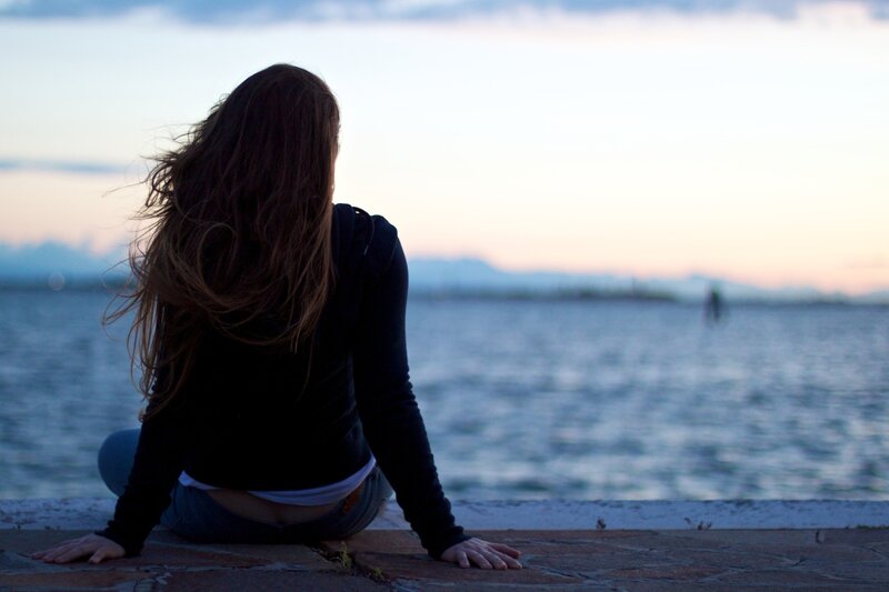 woman sitting by the water