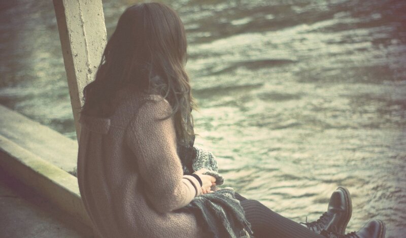 woman sitting by the water