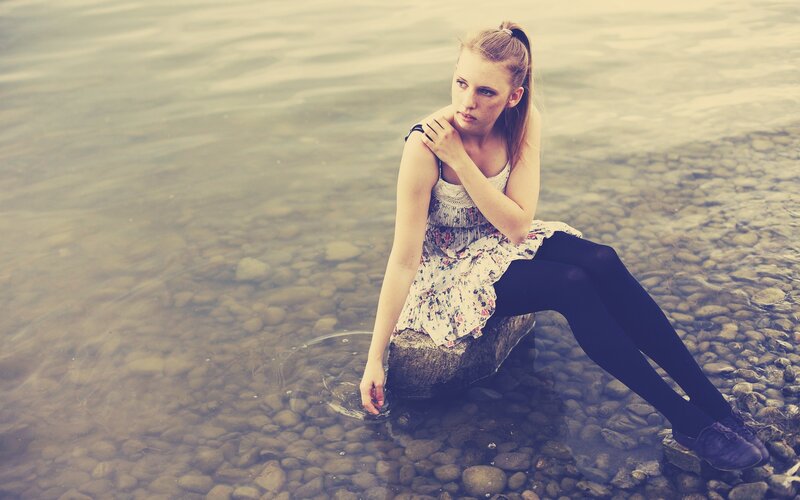 woman sitting by the water