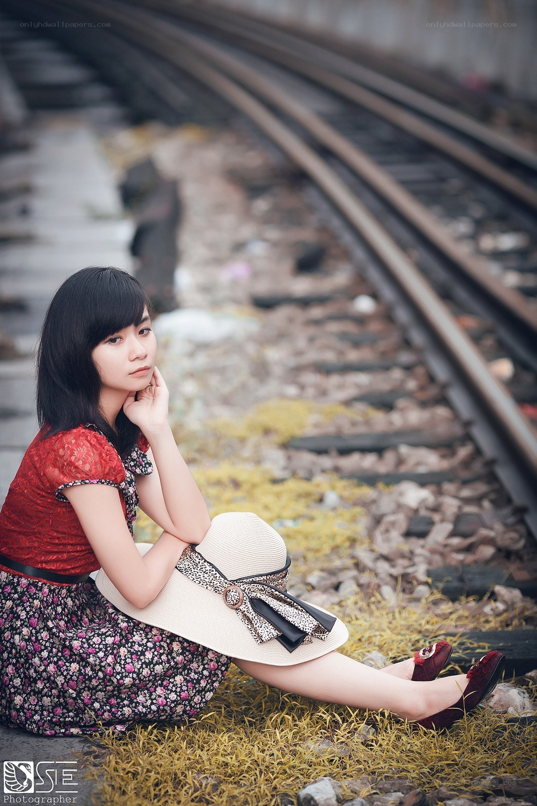 Woman sitting by train tracks
