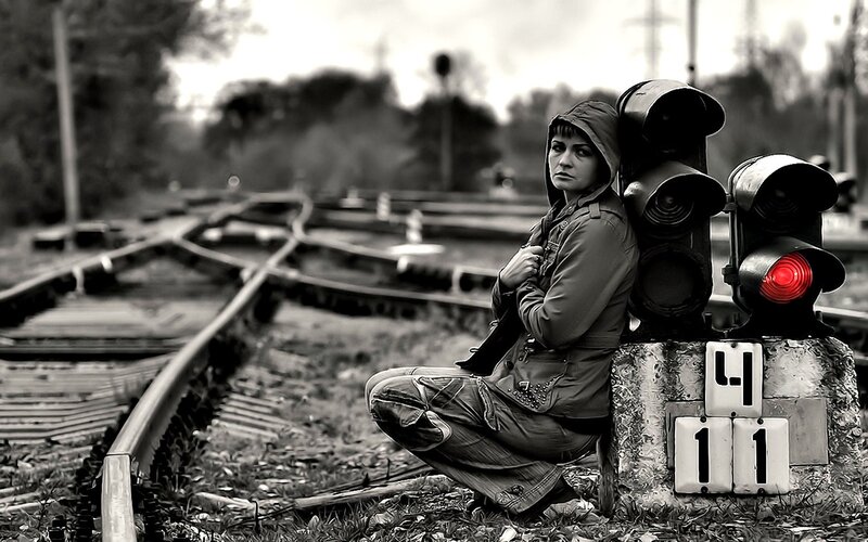 woman sitting by train tracks