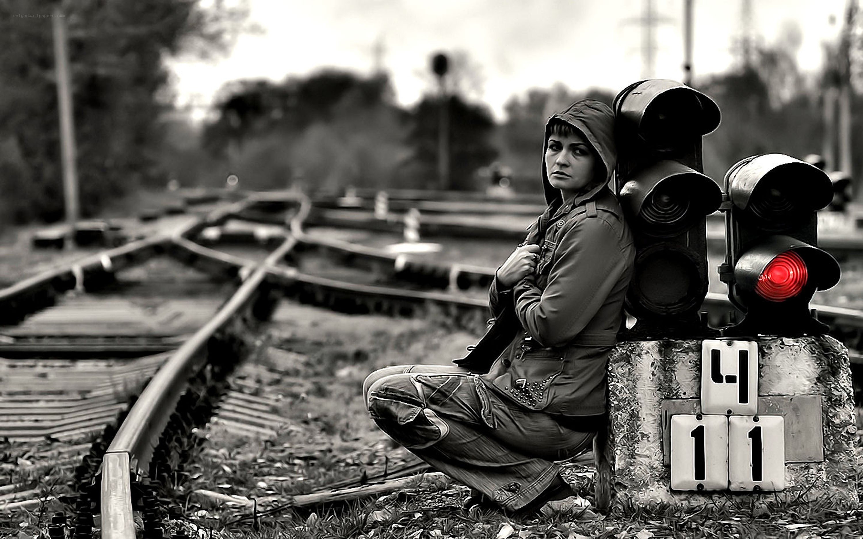 woman sitting by train tracks