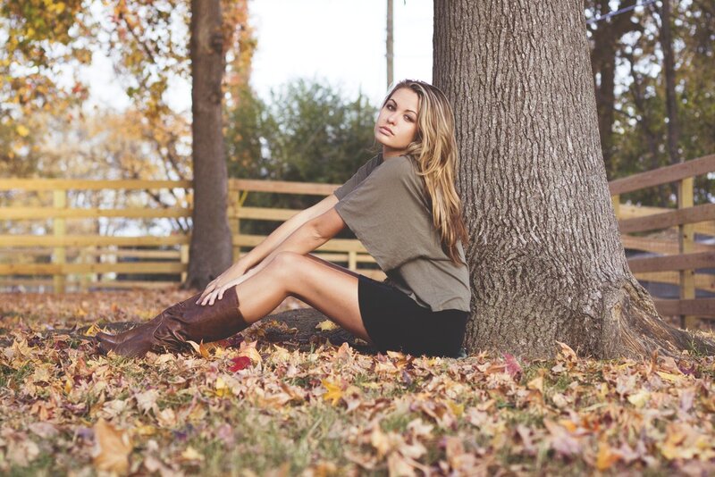 woman sitting by tree in autumn