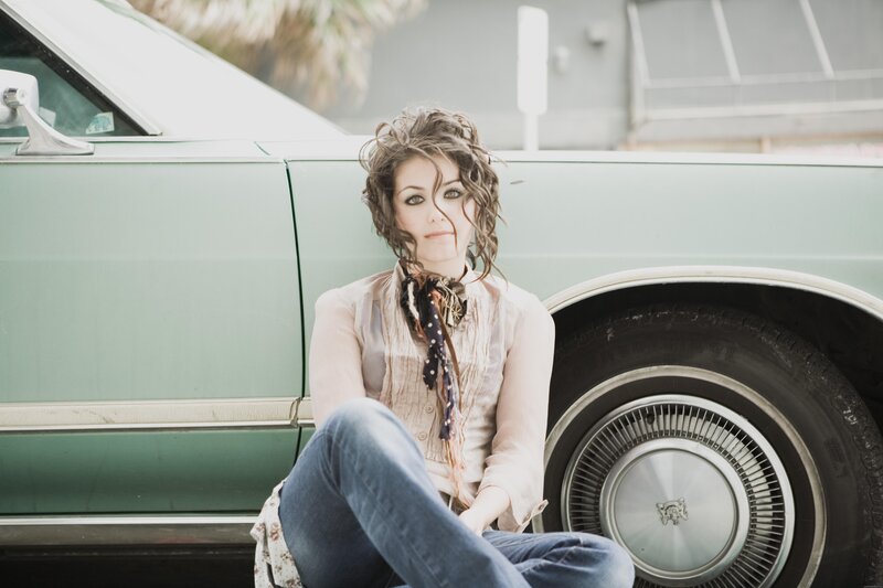 woman sitting by vintage car