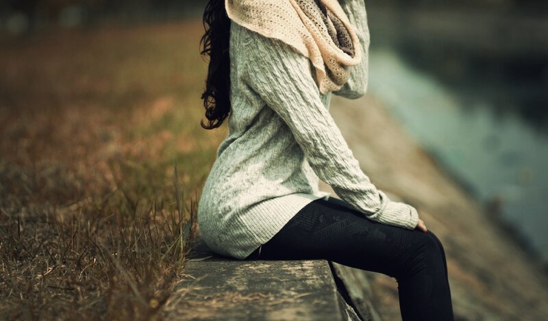 woman sitting by water