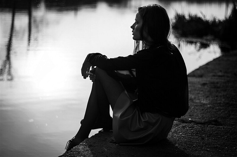 Woman Sitting by Water — Black, Contemplative