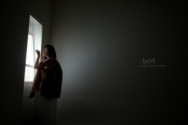 woman sitting by window in dim light