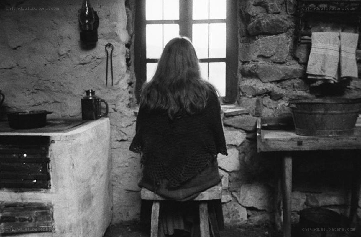 woman sitting by window in rustic kitchen
