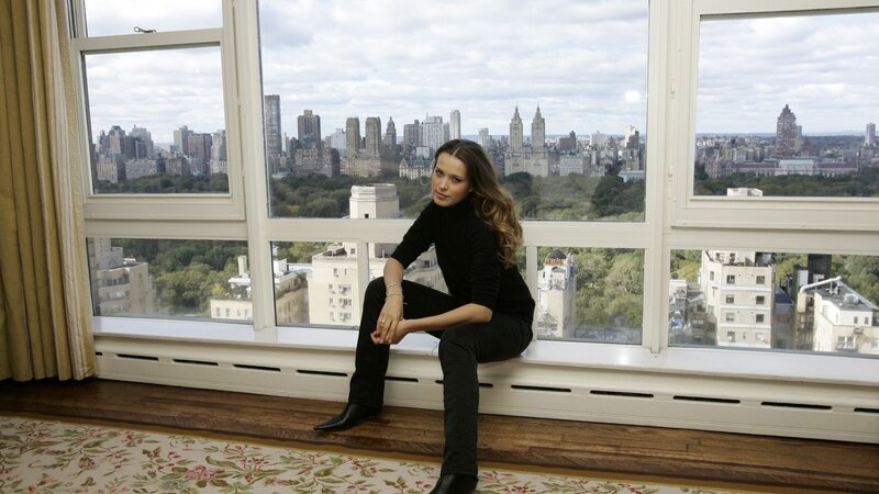 woman sitting by window with city view