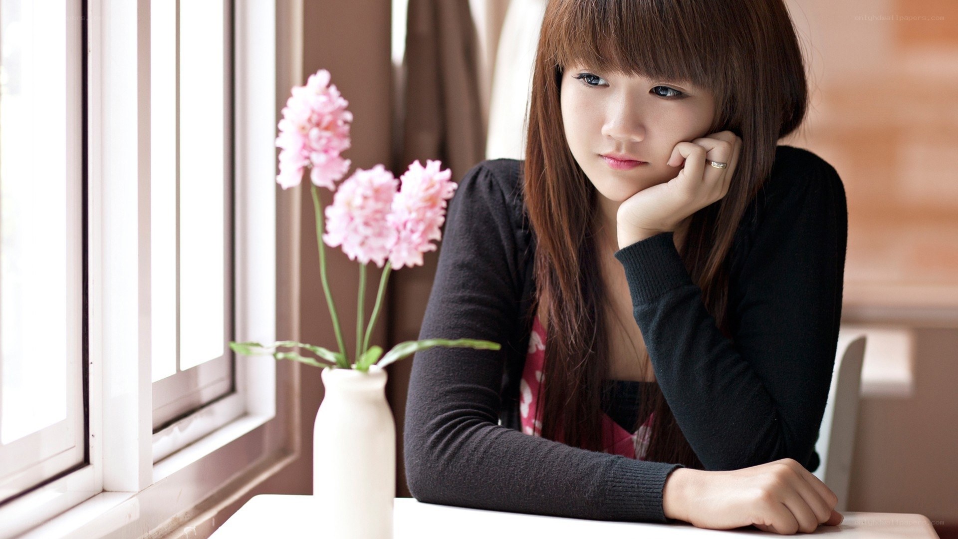 woman sitting by window with flowers