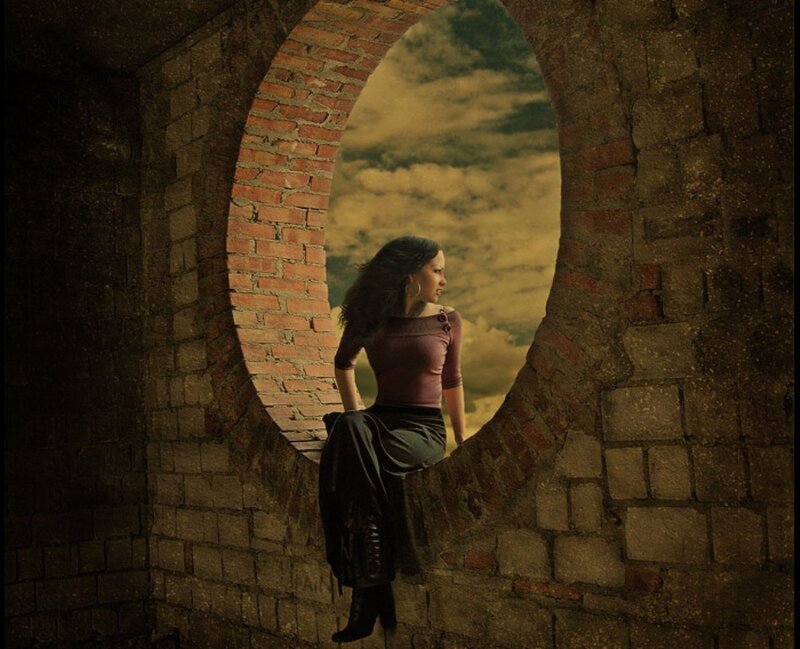 woman sitting in a brick archway