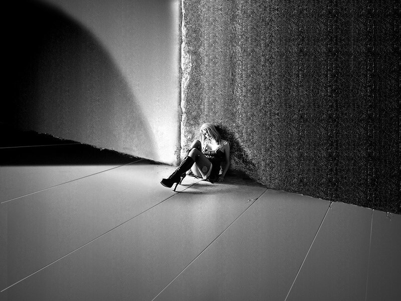 woman sitting in a dark corner