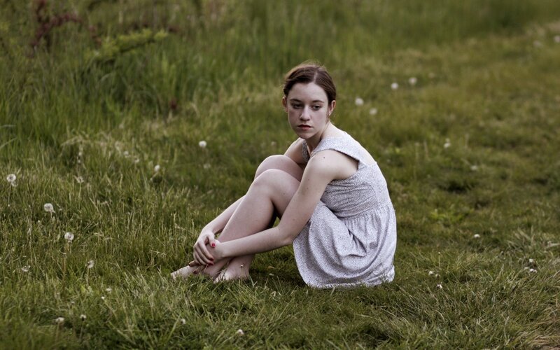woman sitting in a grassy field
