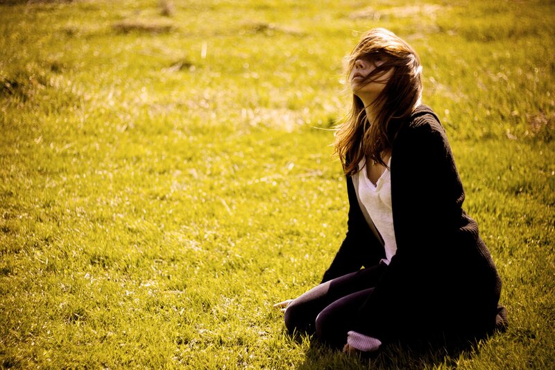 woman sitting in a grassy field