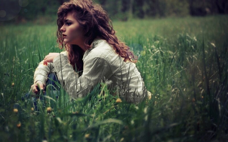 woman sitting in a grassy field