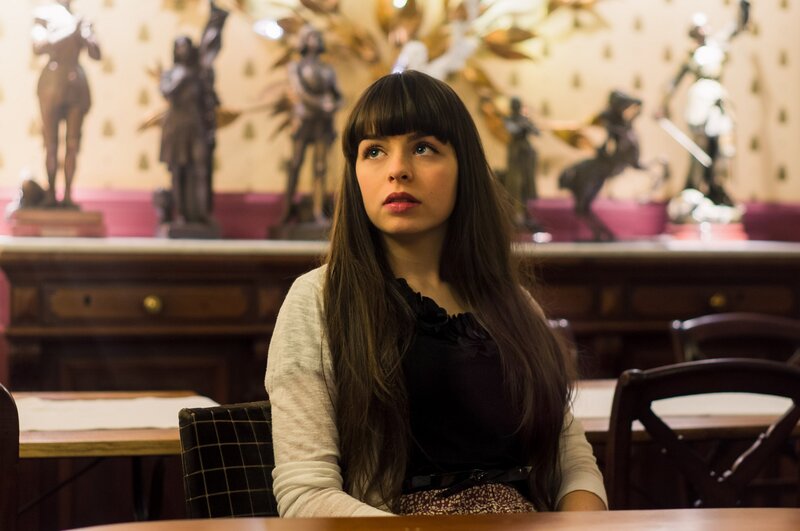 woman sitting in a room with statues