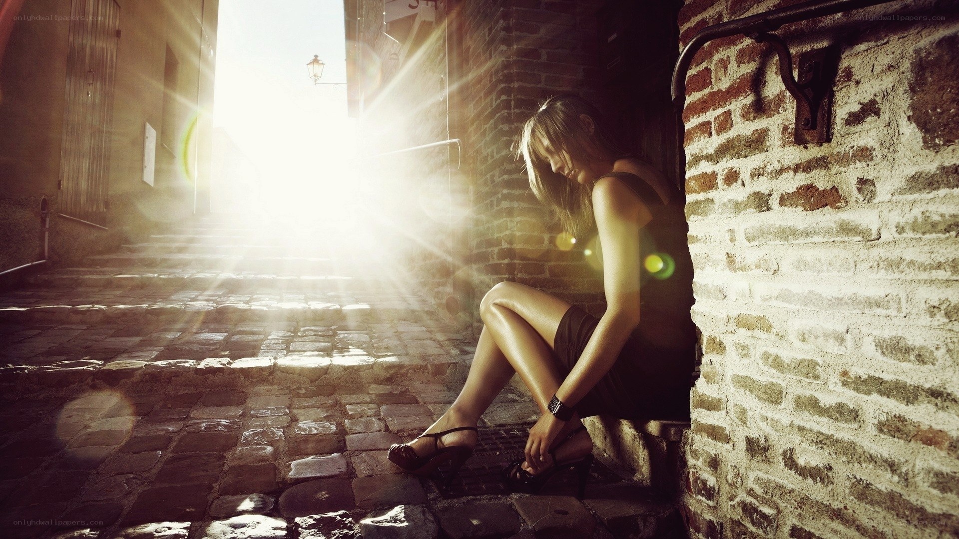 woman sitting in alley at sunset