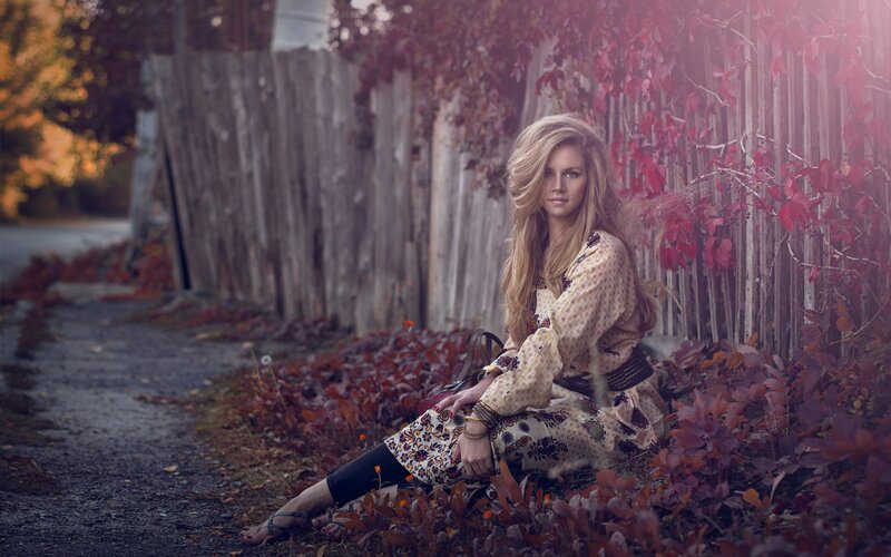 woman sitting in autumn foliage