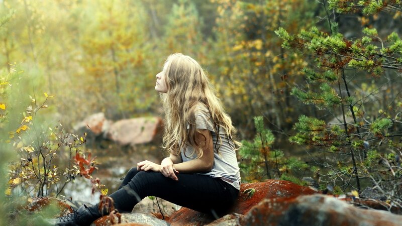 Woman sitting in autumn forest