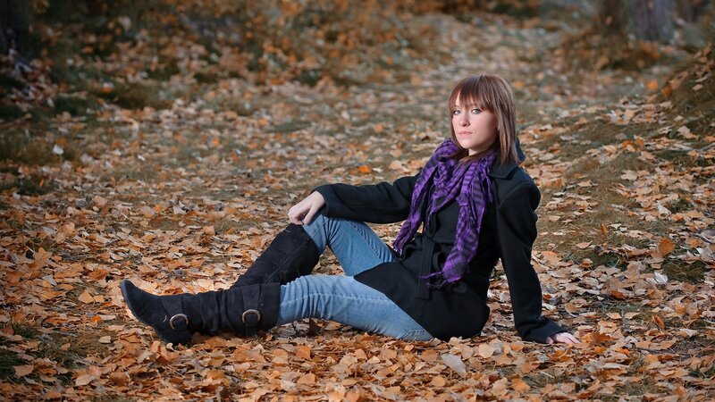 woman sitting in autumn leaves