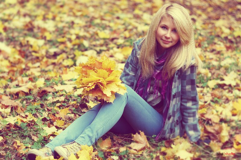 woman sitting in autumn leaves