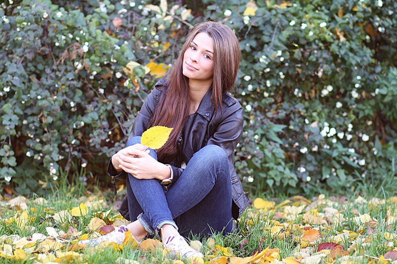 woman sitting in autumn leaves