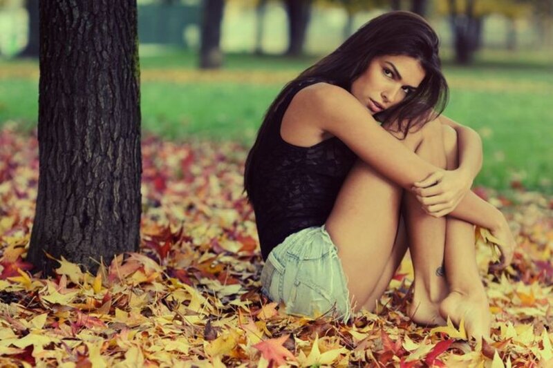 woman sitting in autumn leaves
