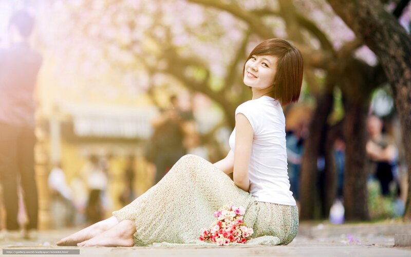 Woman sitting in cherry blossom park