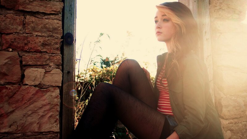 woman sitting in doorway at sunset