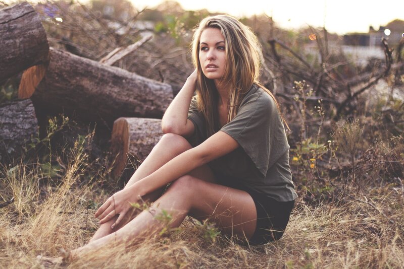 woman sitting in dry grass