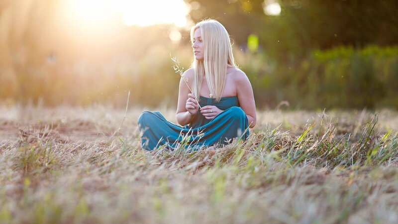 Woman Sitting in Field — Green, Serene, Sunset, Photograph