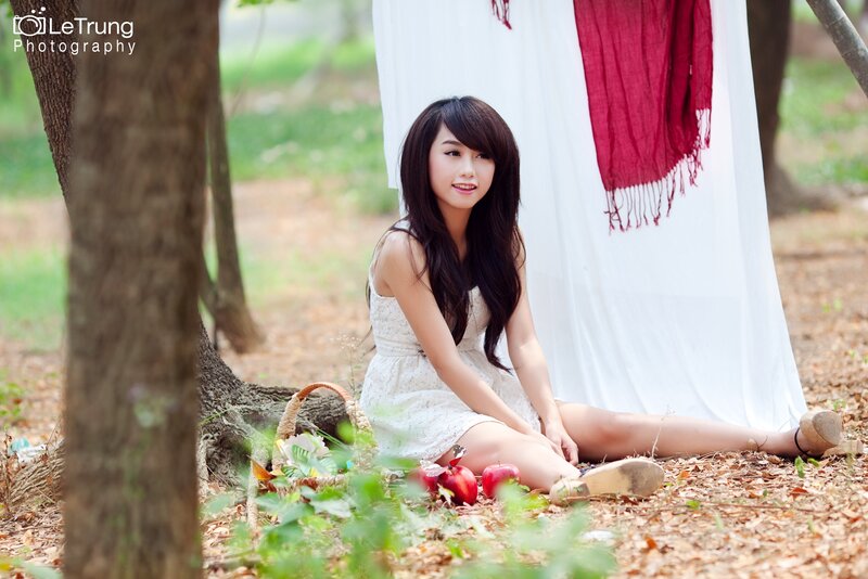 Woman sitting in forest with apples