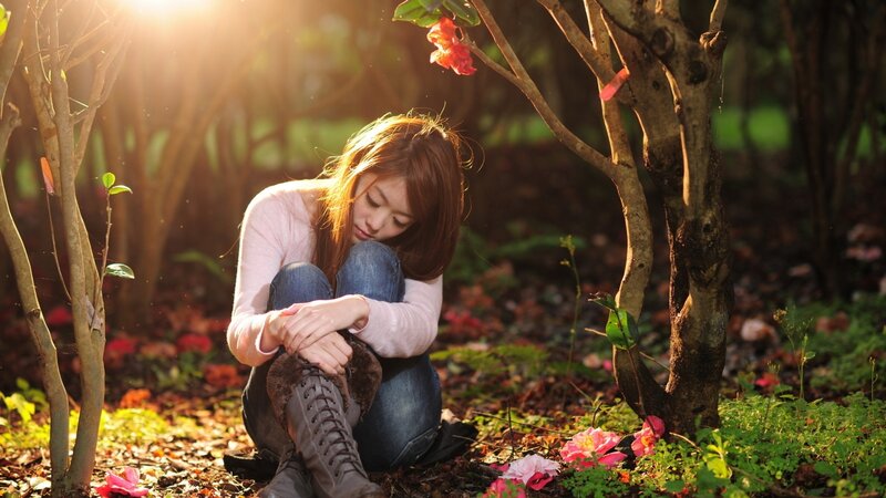 woman sitting in garden at sunset