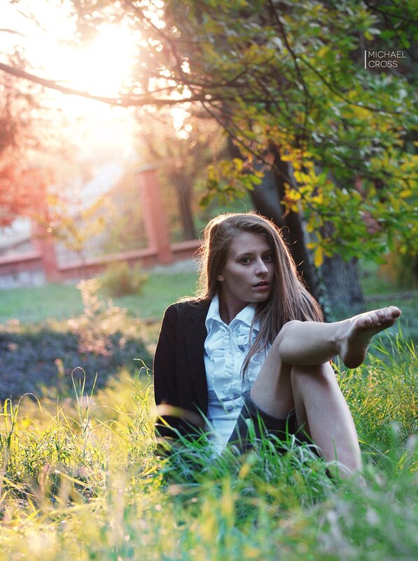 Woman sitting in grass at sunset