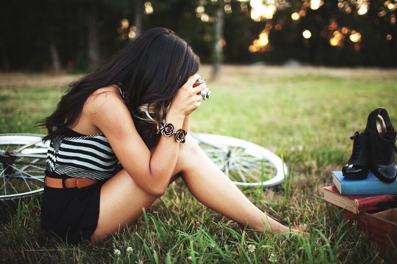 woman sitting in grass with camera