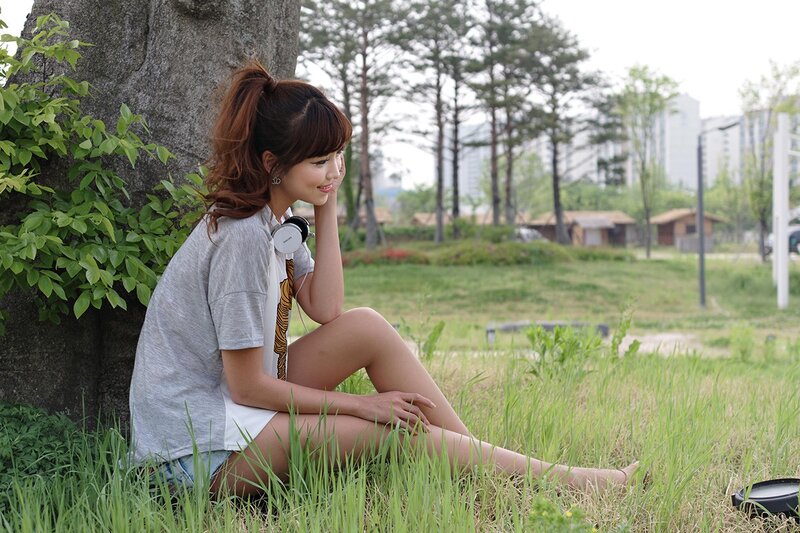 woman sitting in grass with headphones