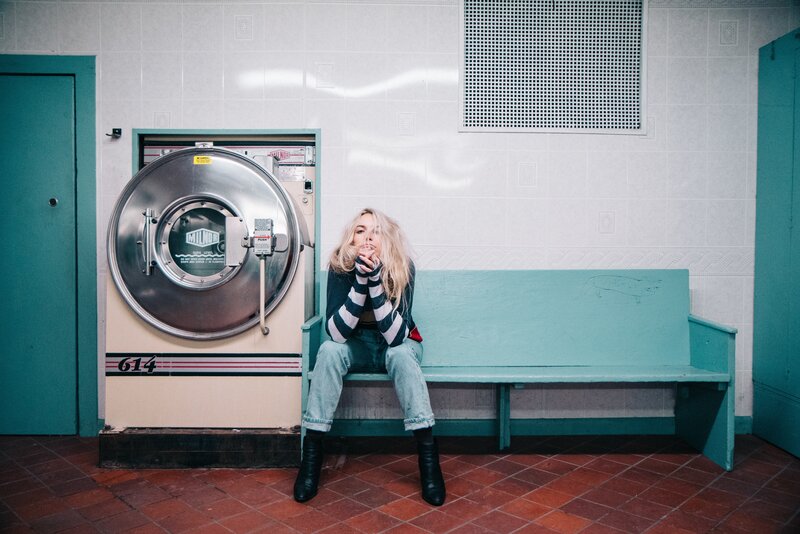 Woman sitting in laundromat