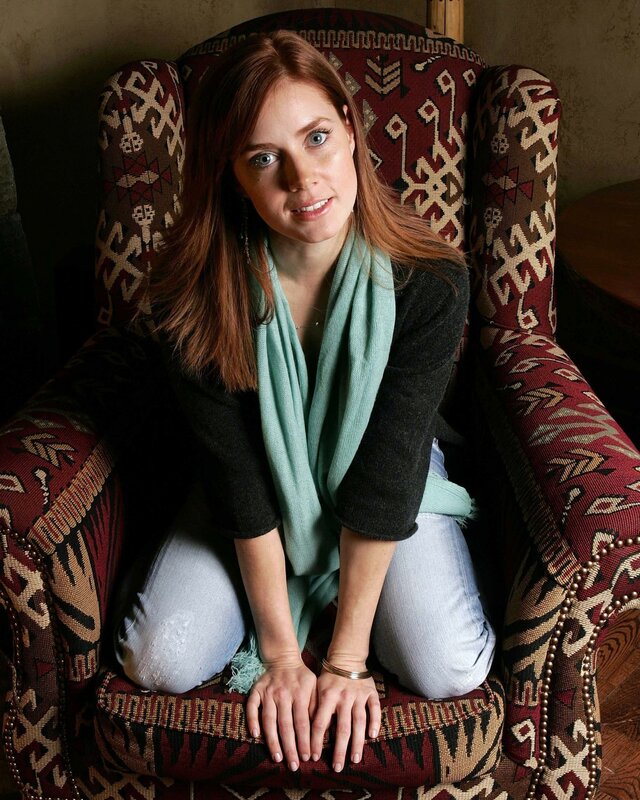 woman sitting in patterned armchair