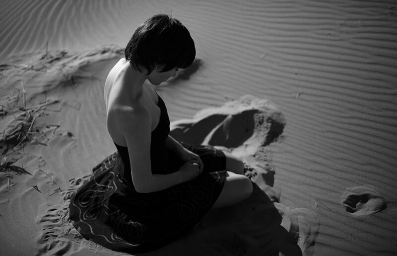 Woman Sitting in Sand — Black