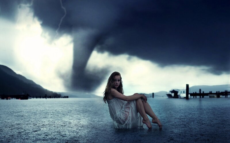 Woman sitting in storm with tornado