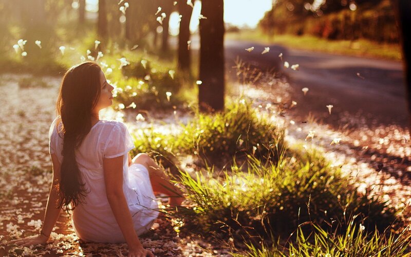 Woman sitting in sunlit park