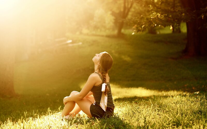 woman sitting in sunlit park