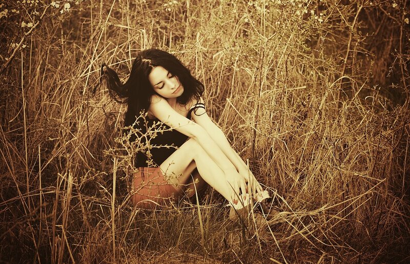 woman sitting in tall grass