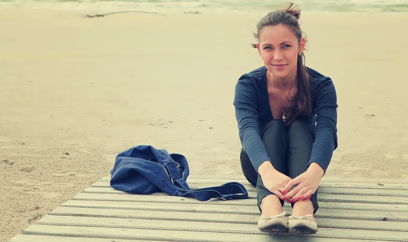 woman sitting on a boardwalk