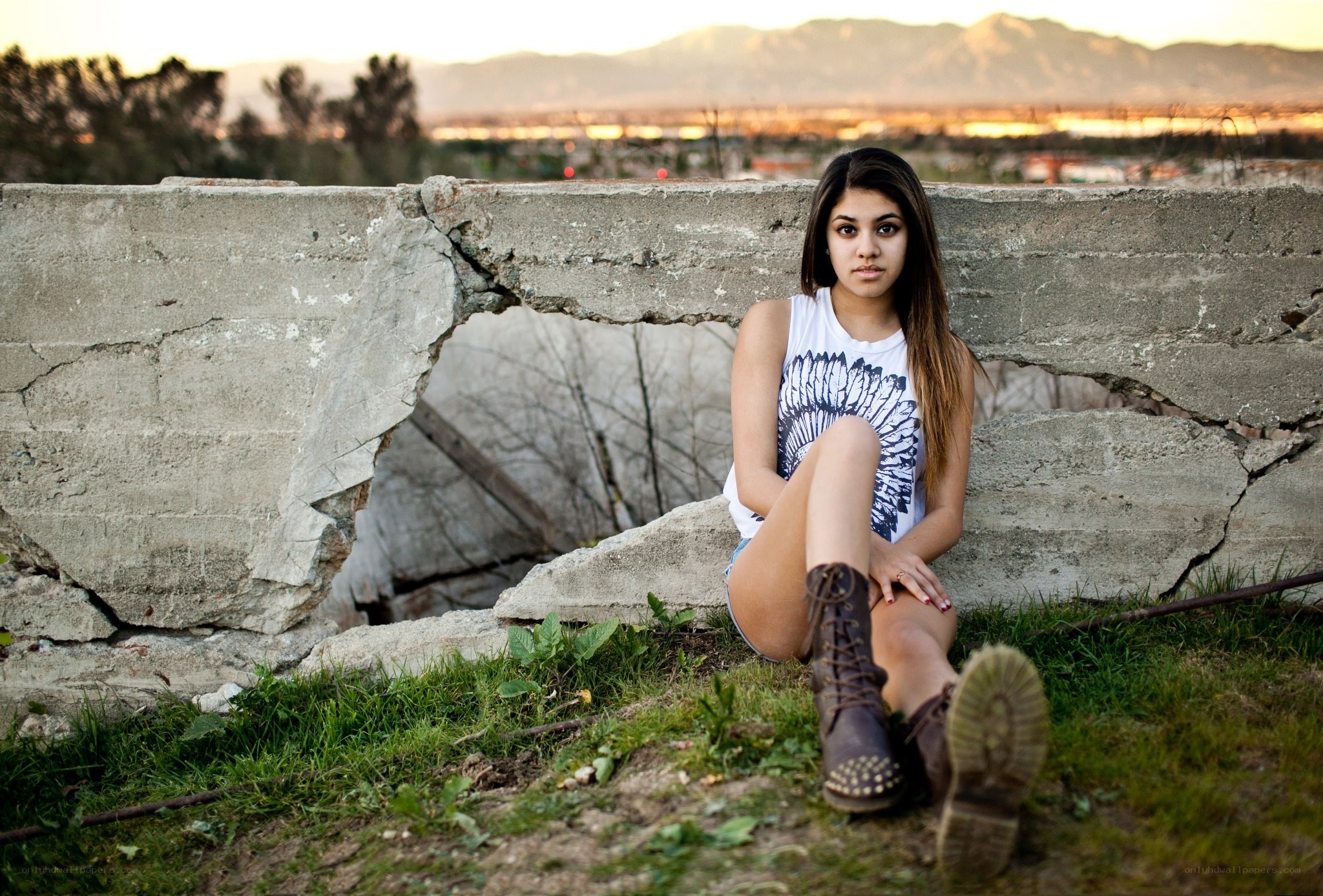 Woman sitting on a broken wall