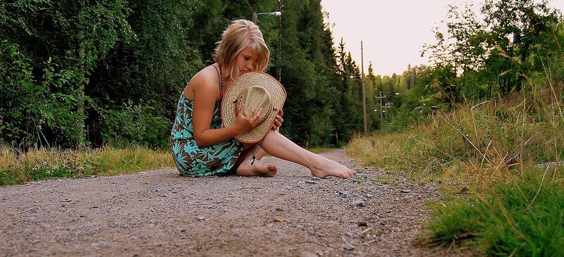 Woman sitting on a dirt road